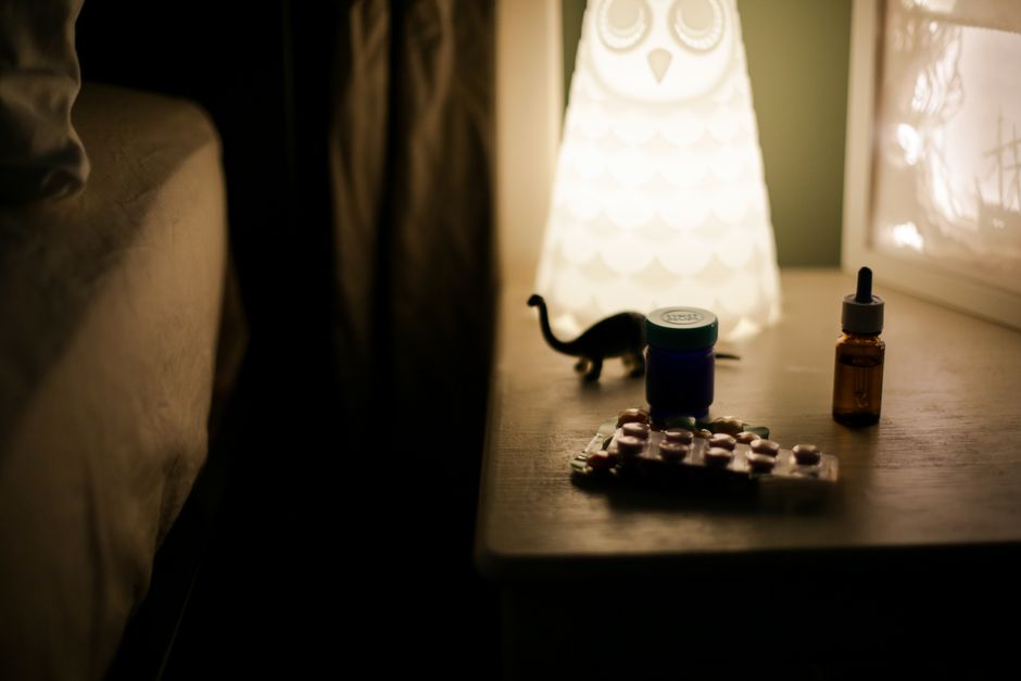 person sleeping peacefully in bed at night with vitamins on nightstand